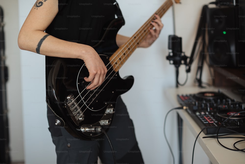 a man playing a bass guitar in a recording studio