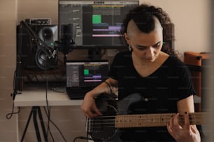 a woman playing a guitar in front of a computer