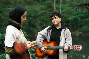 two people standing next to each other with a guitar