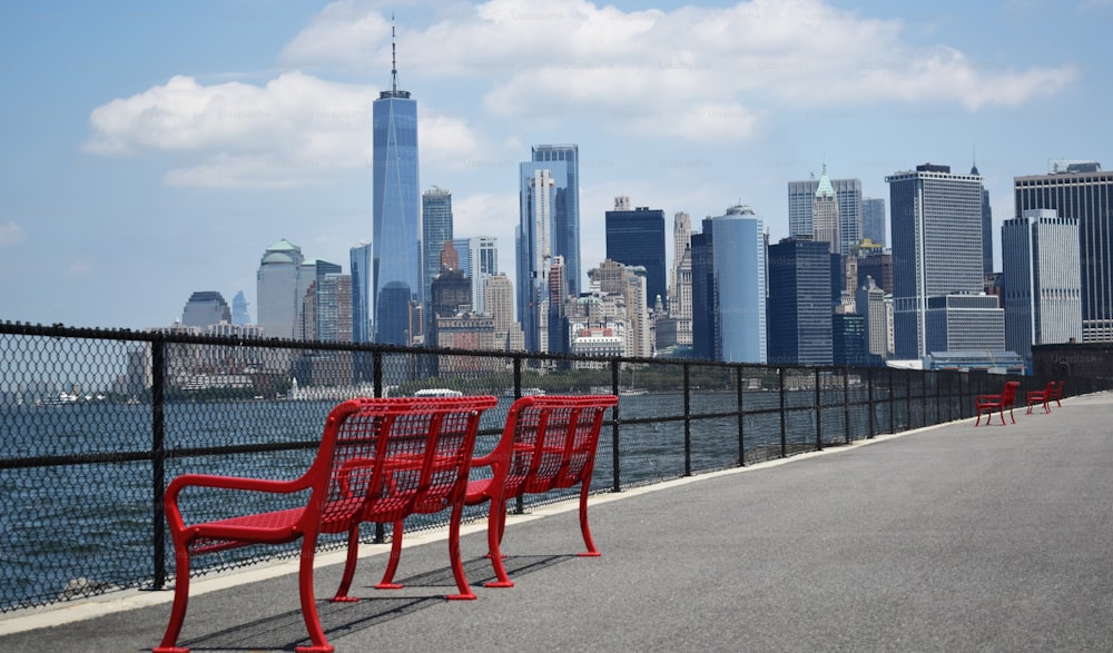 a row of red chairs sitting on the side of a road