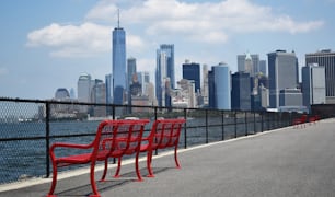 a row of red chairs sitting on the side of a road