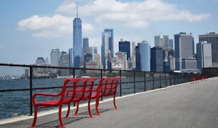 Una fila di sedie rosse sedute sul ciglio di una strada