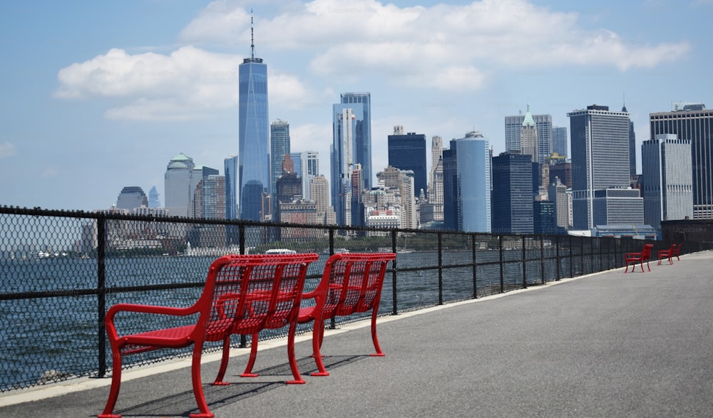 Una fila de sillas rojas sentadas al costado de una carretera