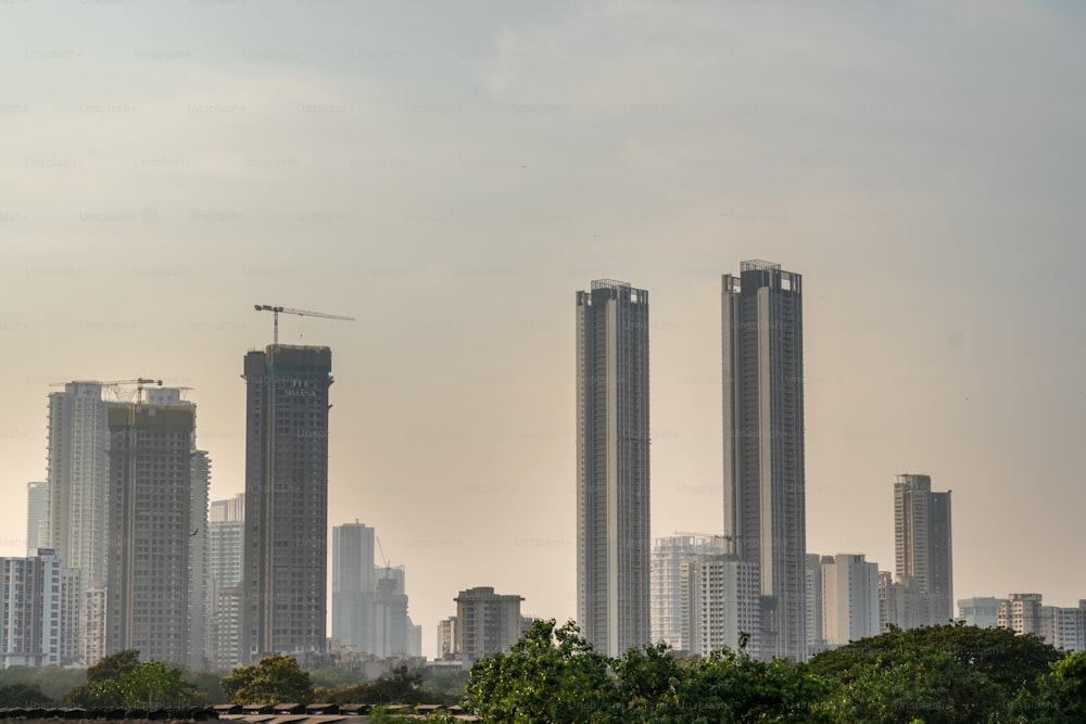 a city skyline with tall buildings and a crane