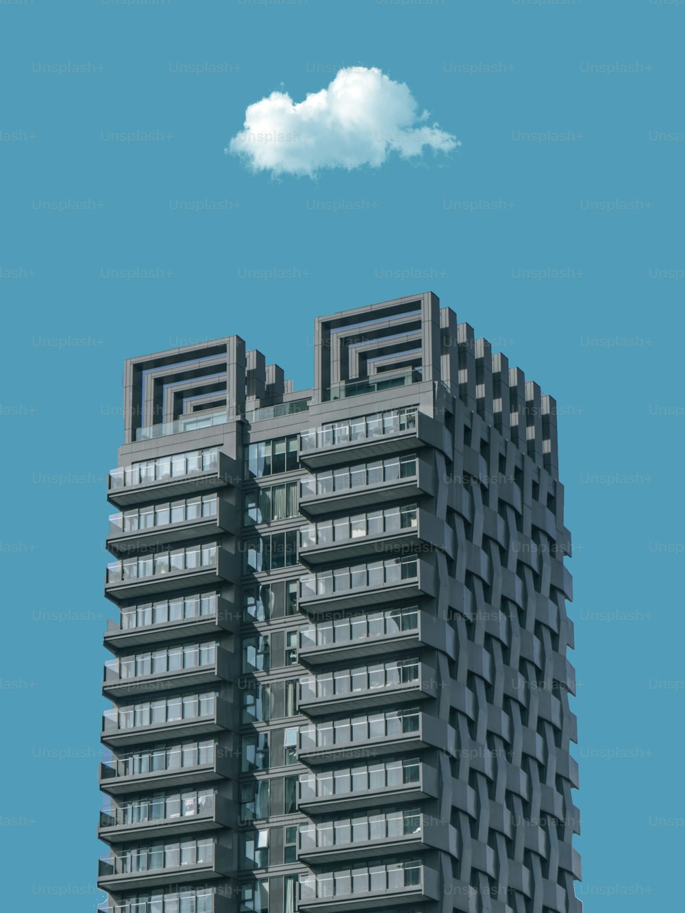 a very tall building with a cloud in the sky
