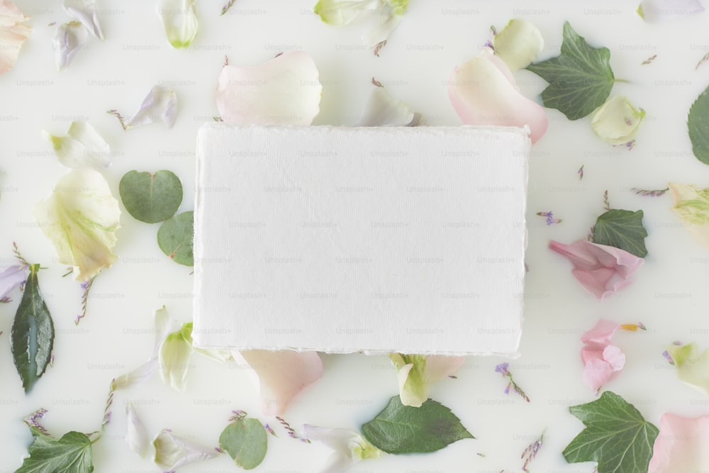 ein quadratisches Stück Papier, umgeben von Blumen