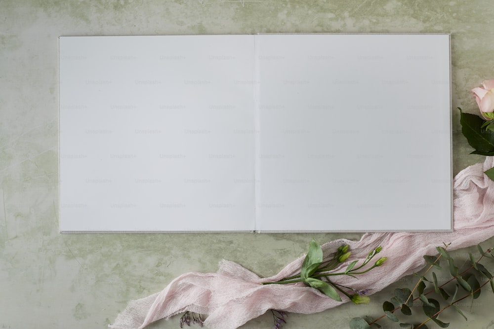 an open book with flowers on a table