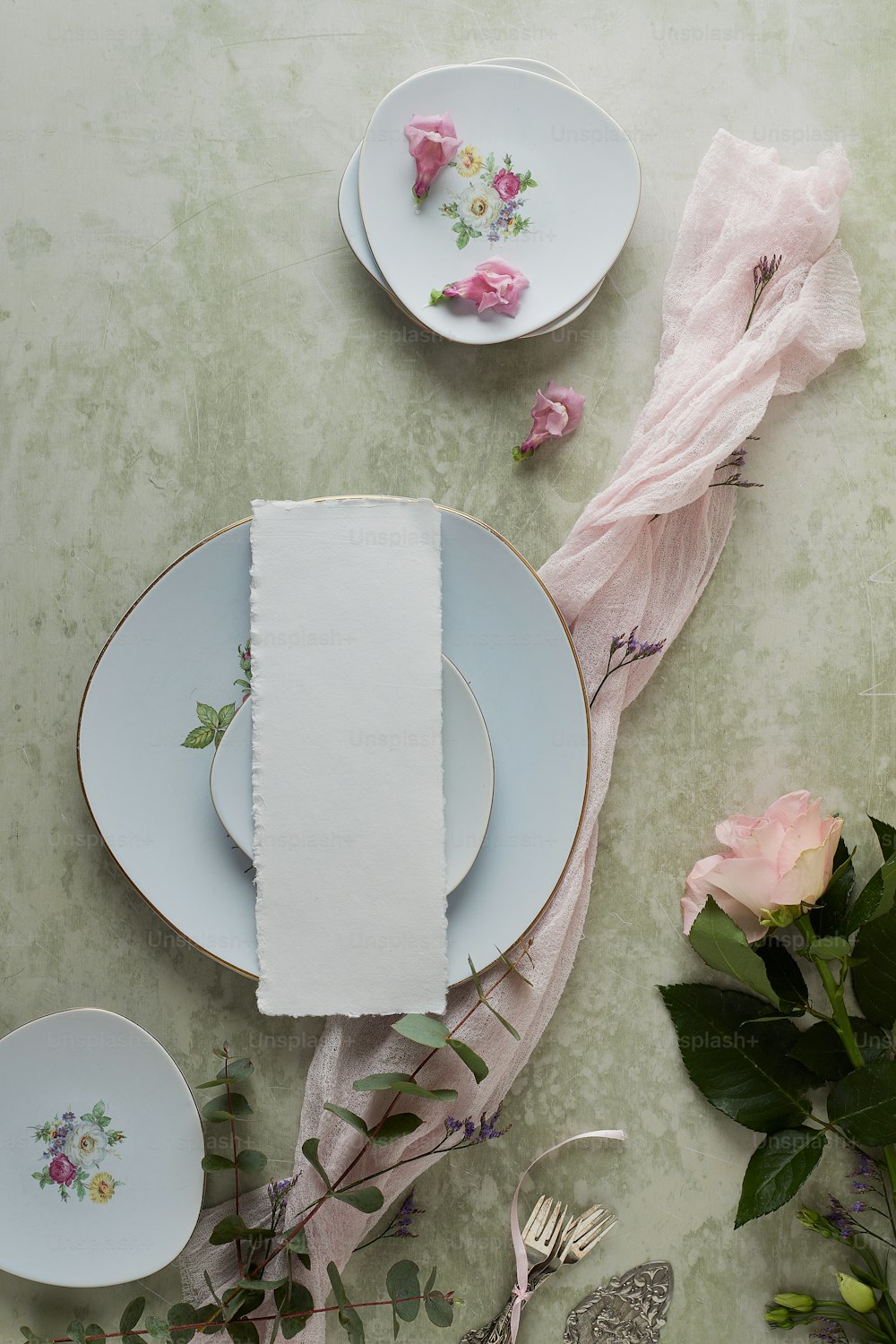 a table topped with plates and flowers on top of a table