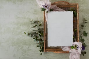 ein Bilderrahmen mit Blumen und einem weißen Blatt Papier