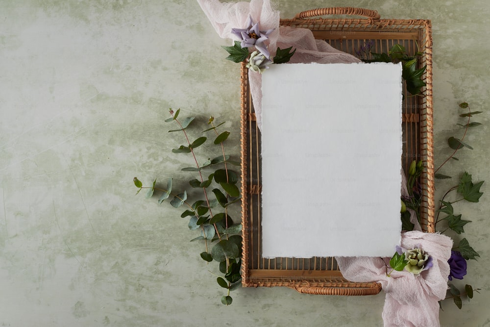 un marco con flores y una hoja de papel blanca