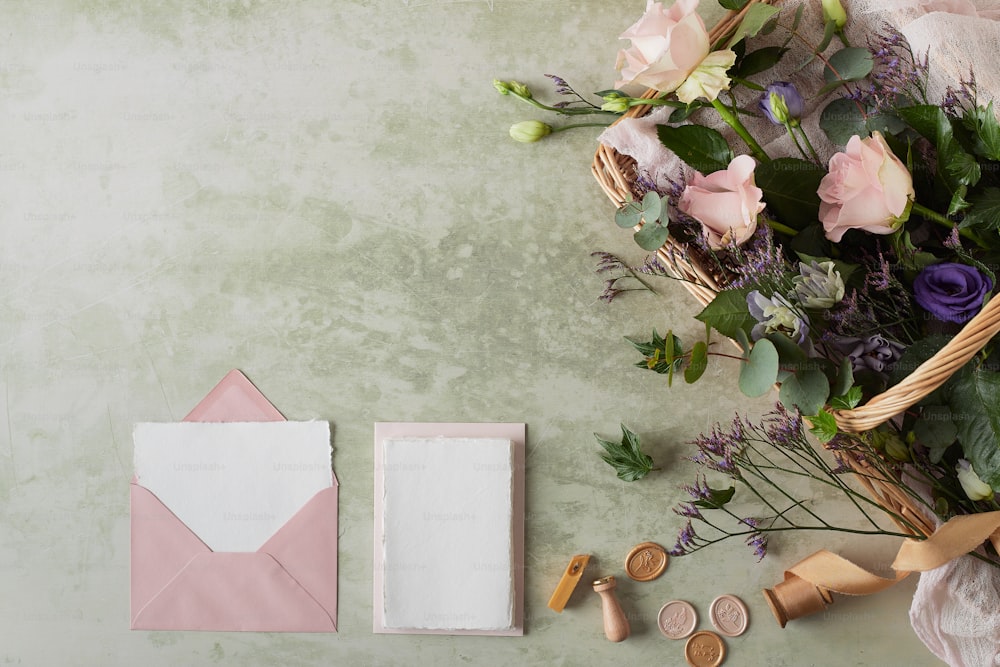a bouquet of flowers next to a pink envelope