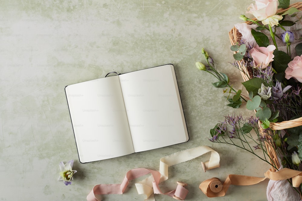 an open book next to a bouquet of flowers