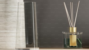 a glass container with a reed diffuser next to a glass vase with a reed