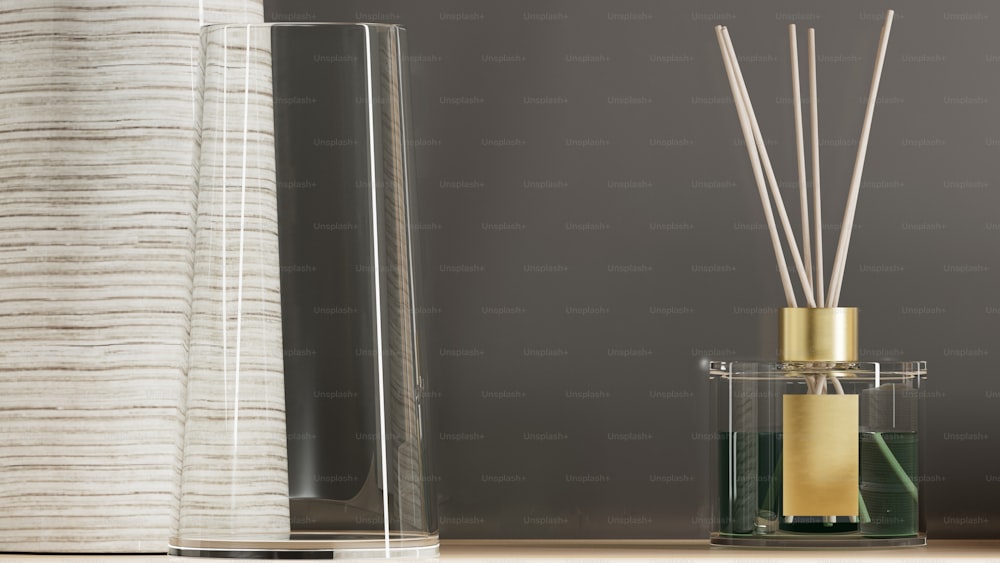 un récipient en verre avec un diffuseur en roseau à côté d’un vase en verre avec un roseau