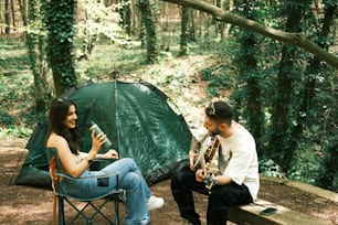 Un homme et une femme assis sur un banc à côté d’une tente