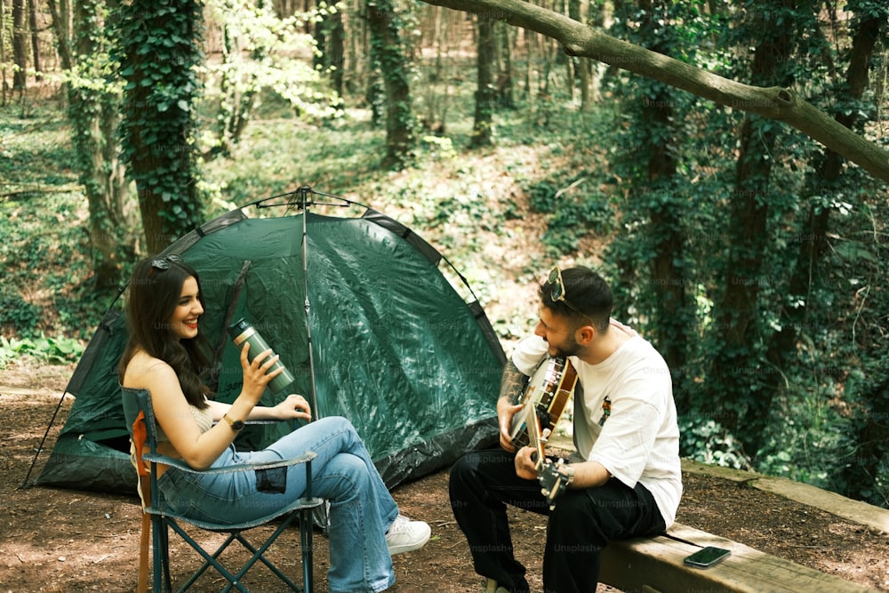 Un uomo e una donna seduti su una panchina accanto a una tenda