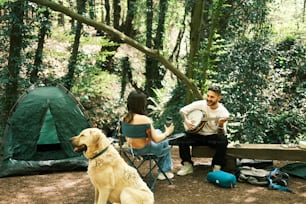 a man and a woman sitting next to a dog