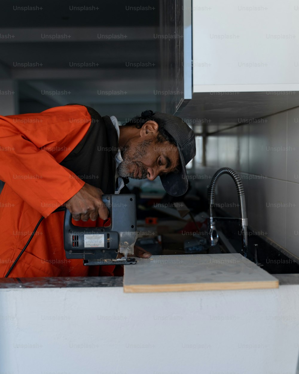 Ein Mann in einem orangefarbenen Overall, der an einer Maschine arbeitet