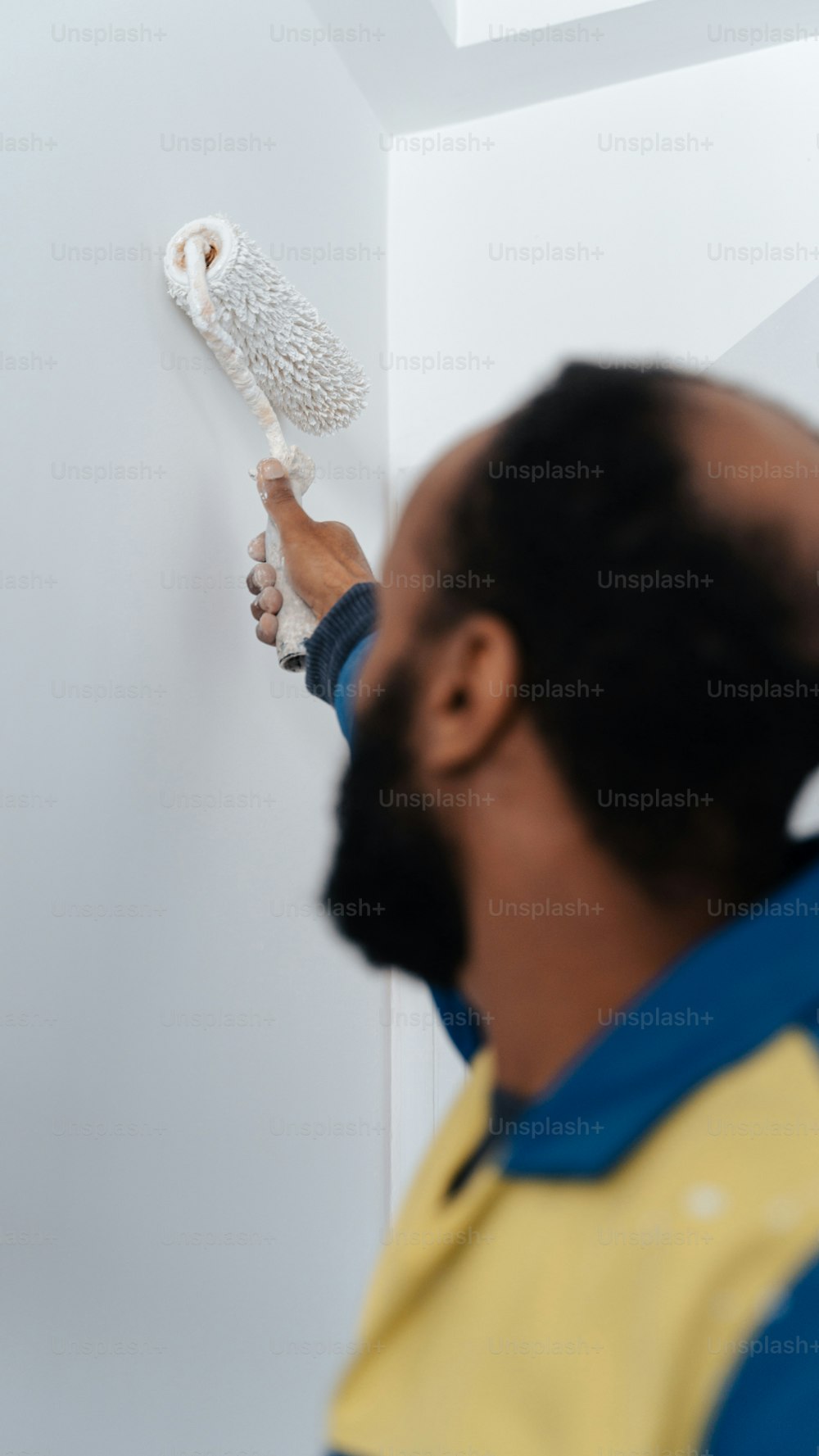 Un hombre está pintando un búho blanco en una pared