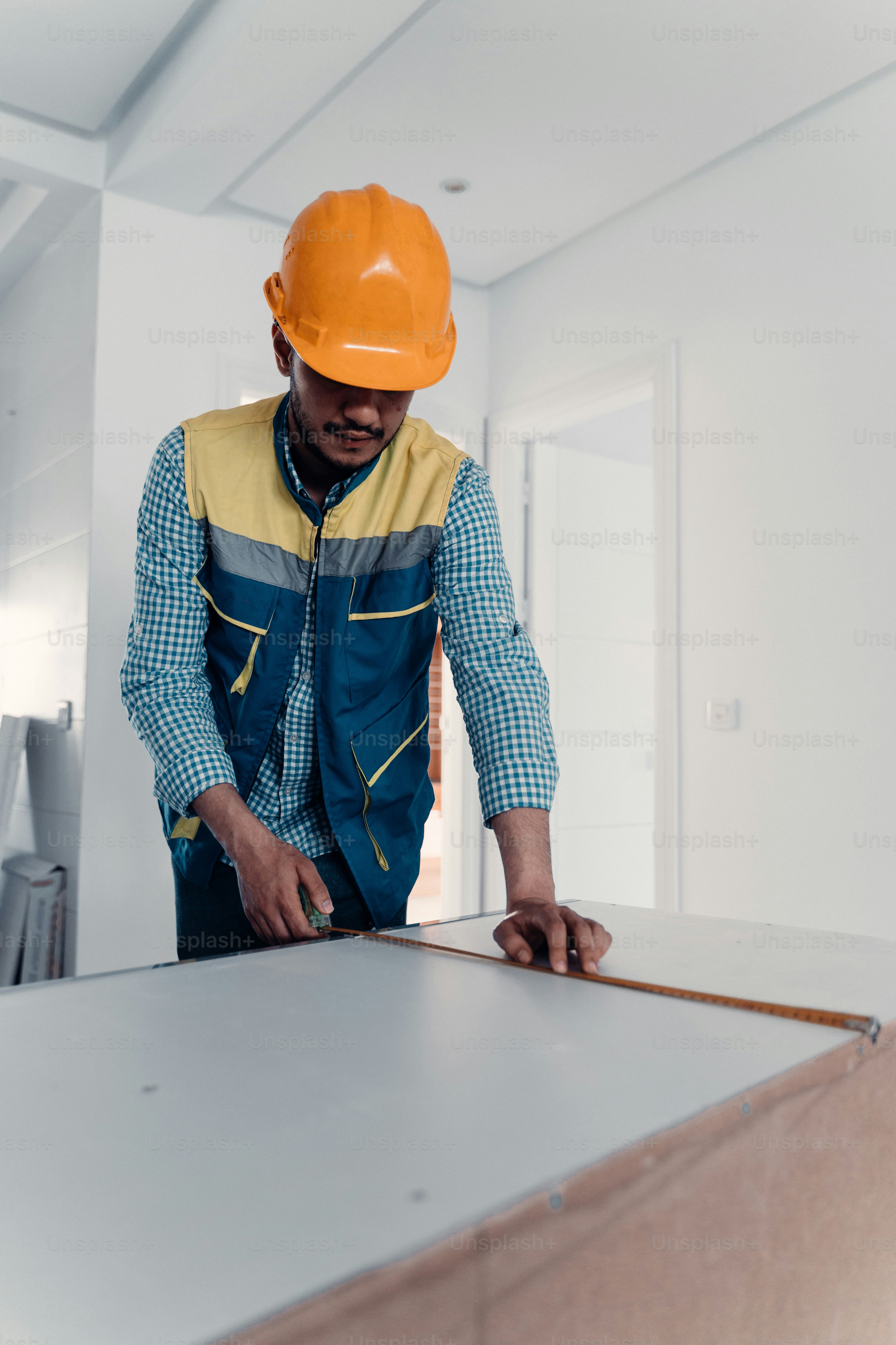a man in a hard hat is working on a piece of wood