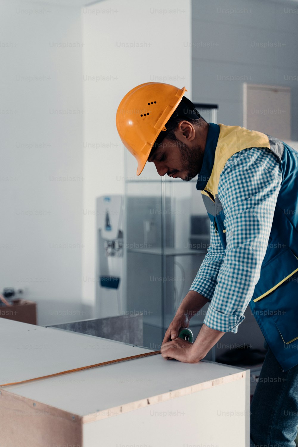 a man in a hard hat cutting a piece of wood