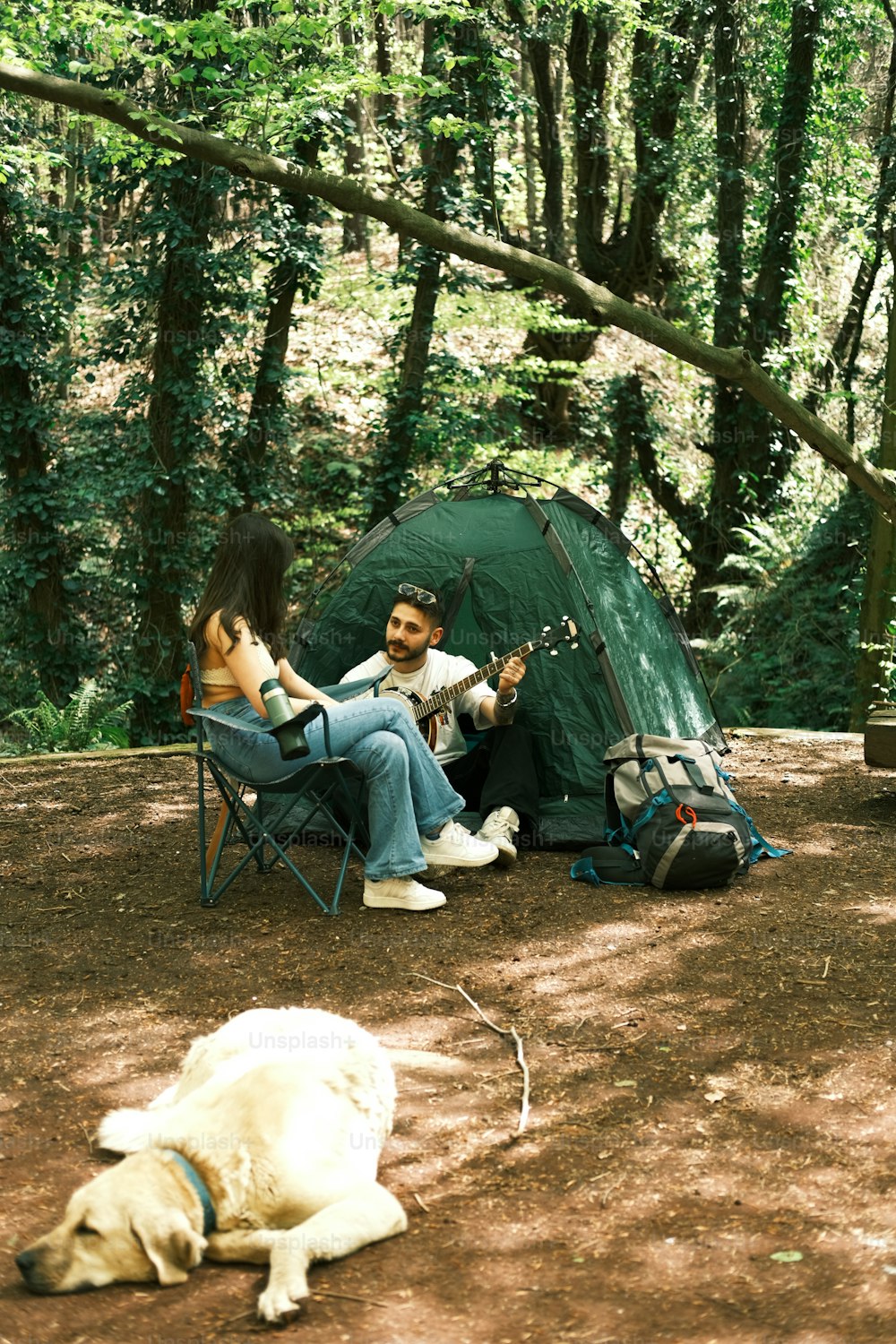 텐트 옆 의자에 앉아 있는 남자와 여자