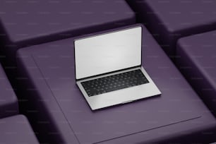 um computador portátil sentado em cima de um sofá roxo