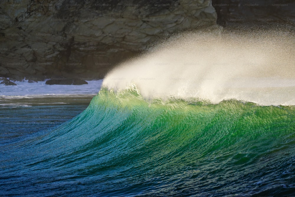 uma grande onda batendo na costa de uma praia