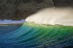 Una grande onda che si infrange sulla riva di una spiaggia