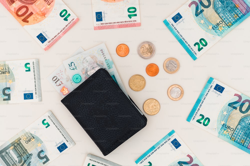 a black wallet sitting on top of a pile of money