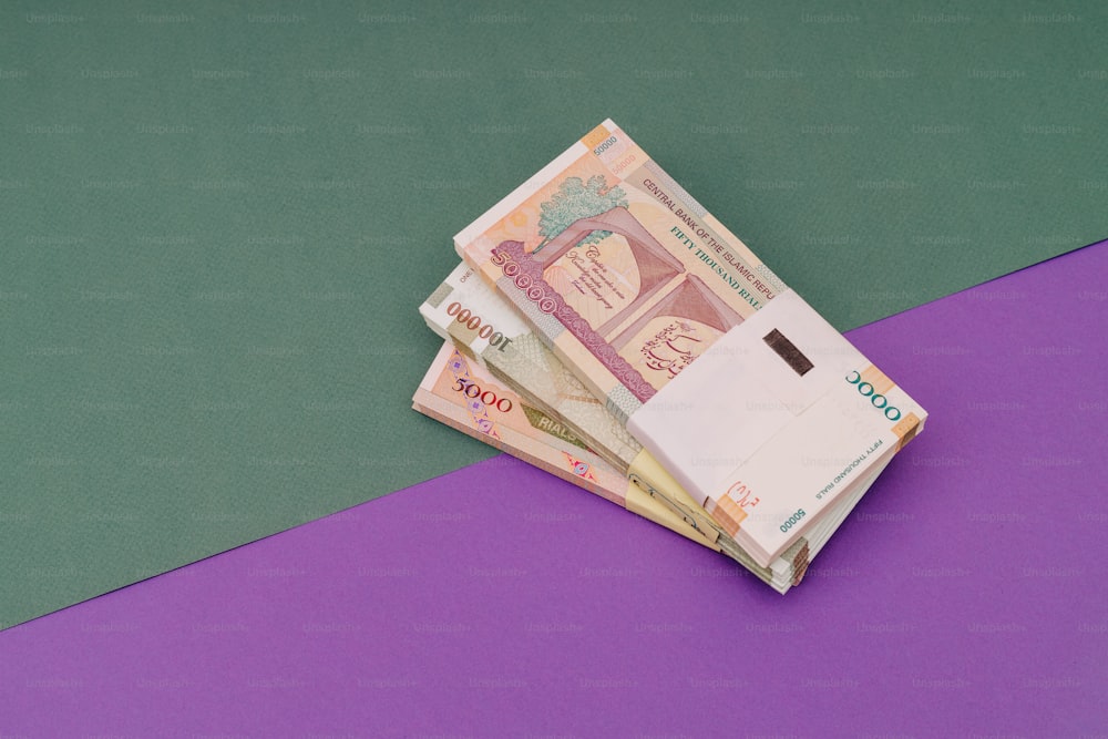 a pile of indian currency sitting on top of a purple table