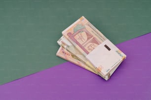 a pile of indian currency sitting on top of a purple table