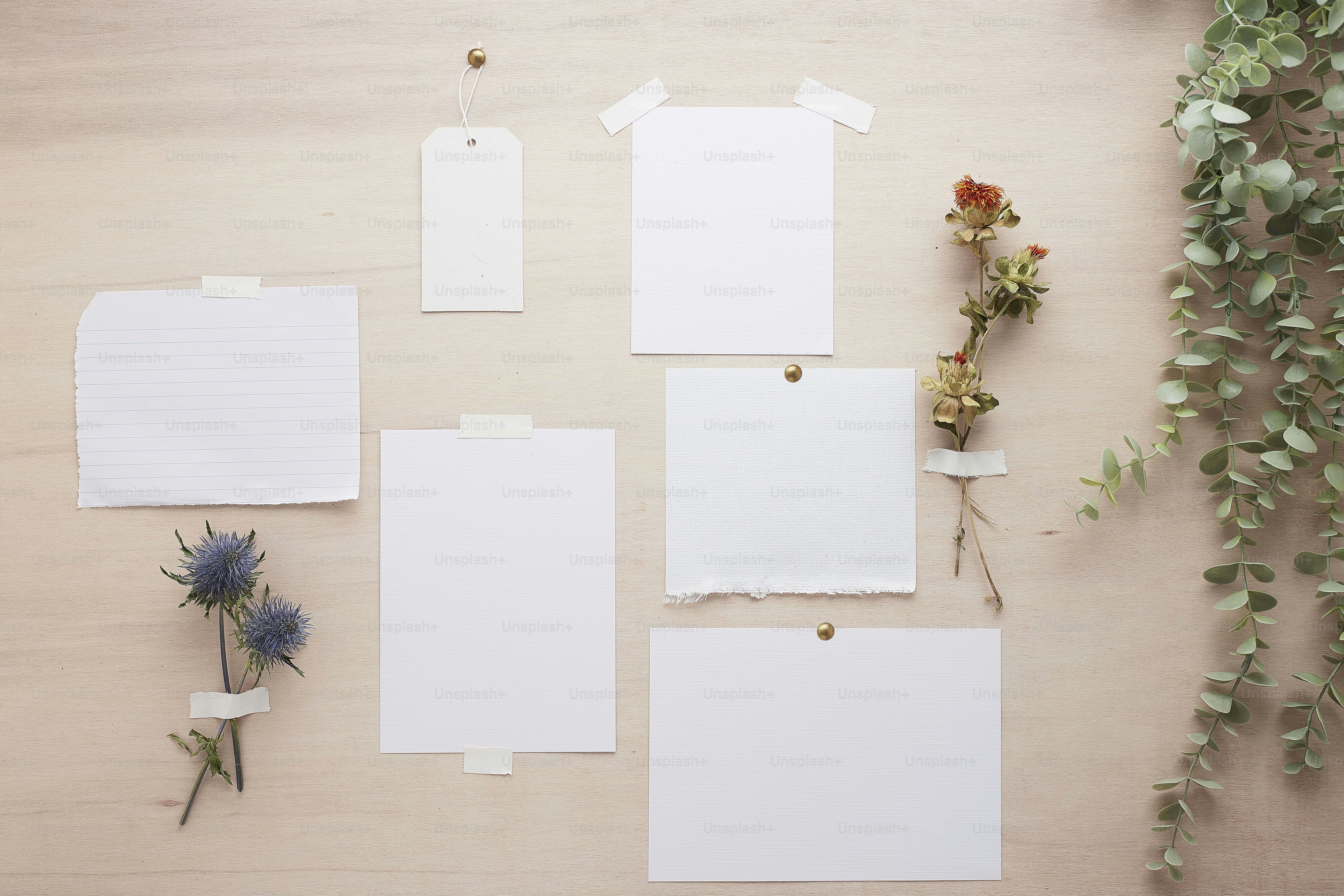 a collection of blank paper and flowers on a table
