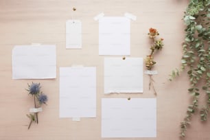 a collection of blank paper and flowers on a table