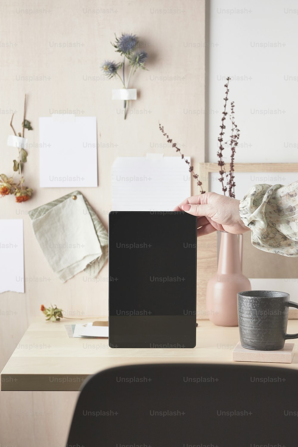 a desk with a computer and a vase of flowers