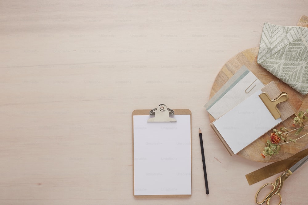 a clipboard with a notepad and a pair of scissors next to it