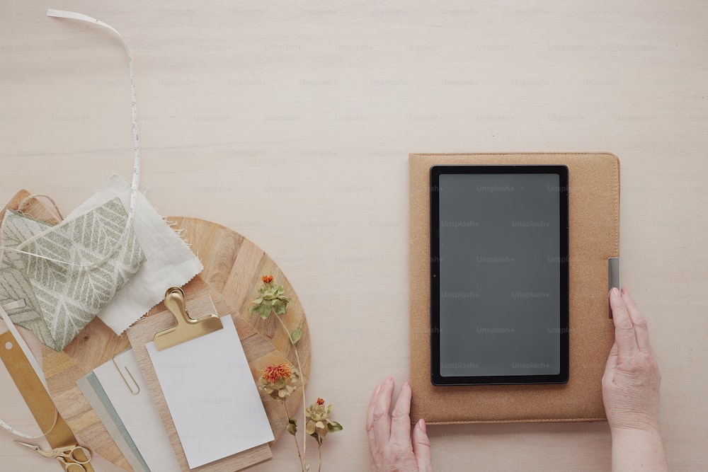 a person holding a tablet next to a cutting board