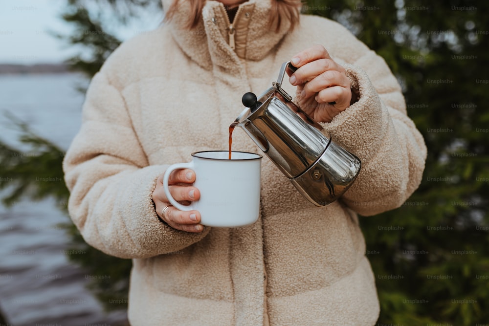 a woman is holding a cup of coffee