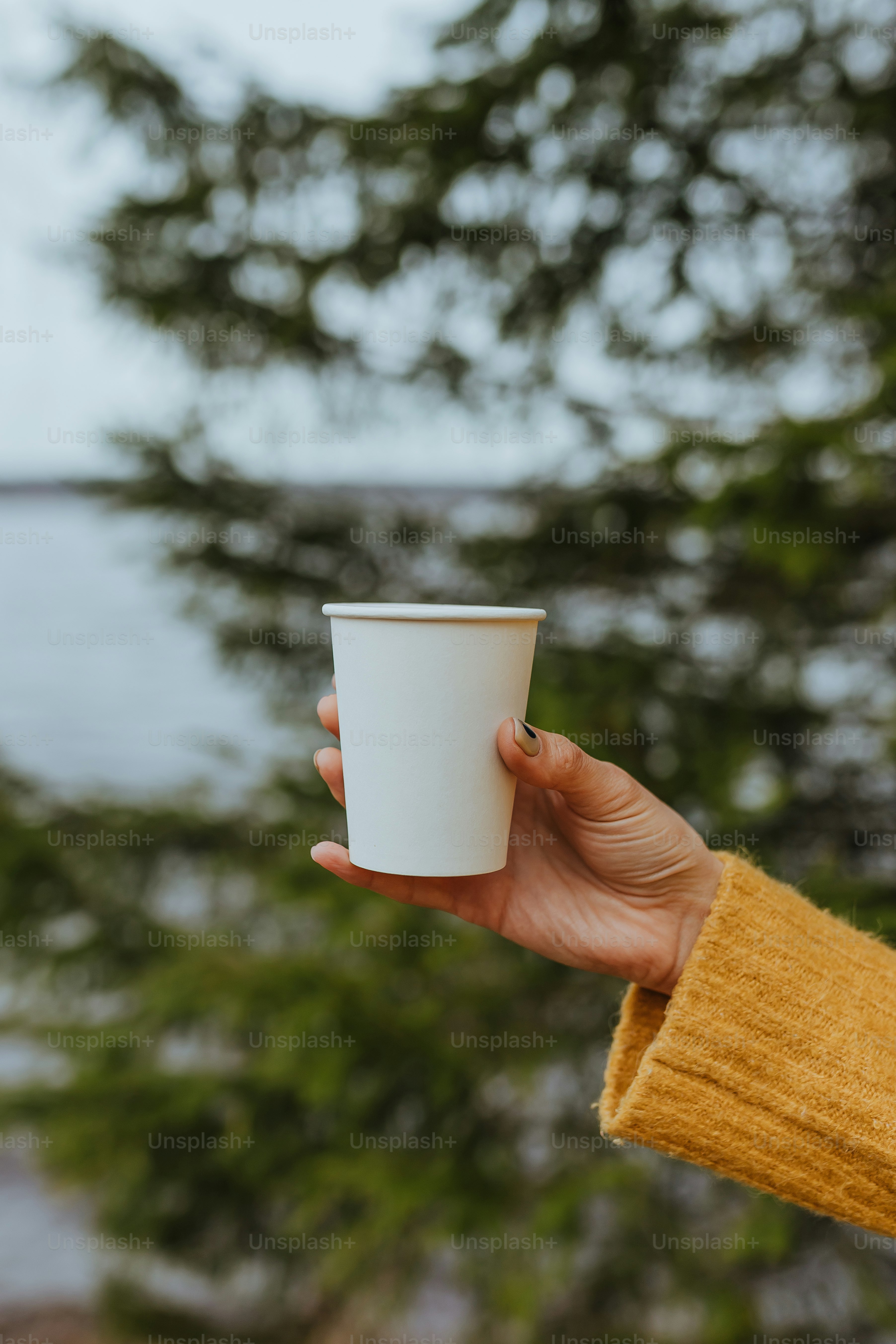 a person holding a cup of coffee in their hand