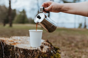 Eine Person gießt Kaffee in eine weiße Tasse
