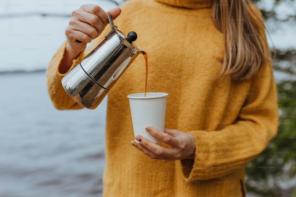 a woman is holding a cup of coffee