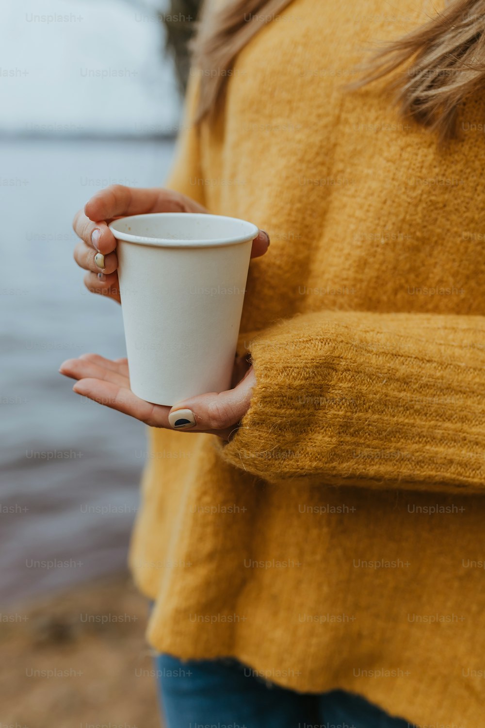 Una donna che tiene una tazza di caffè tra le mani