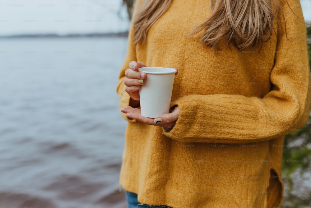 a woman holding a cup of coffee in her hands