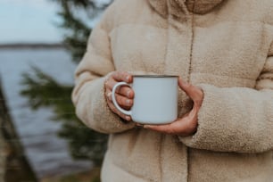 una persona sosteniendo una taza de café en sus manos