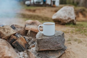 a cup of coffee sitting on top of a pile of rocks
