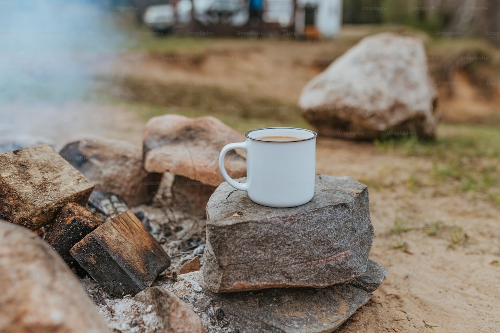 a cup of coffee sitting on top of a pile of rocks