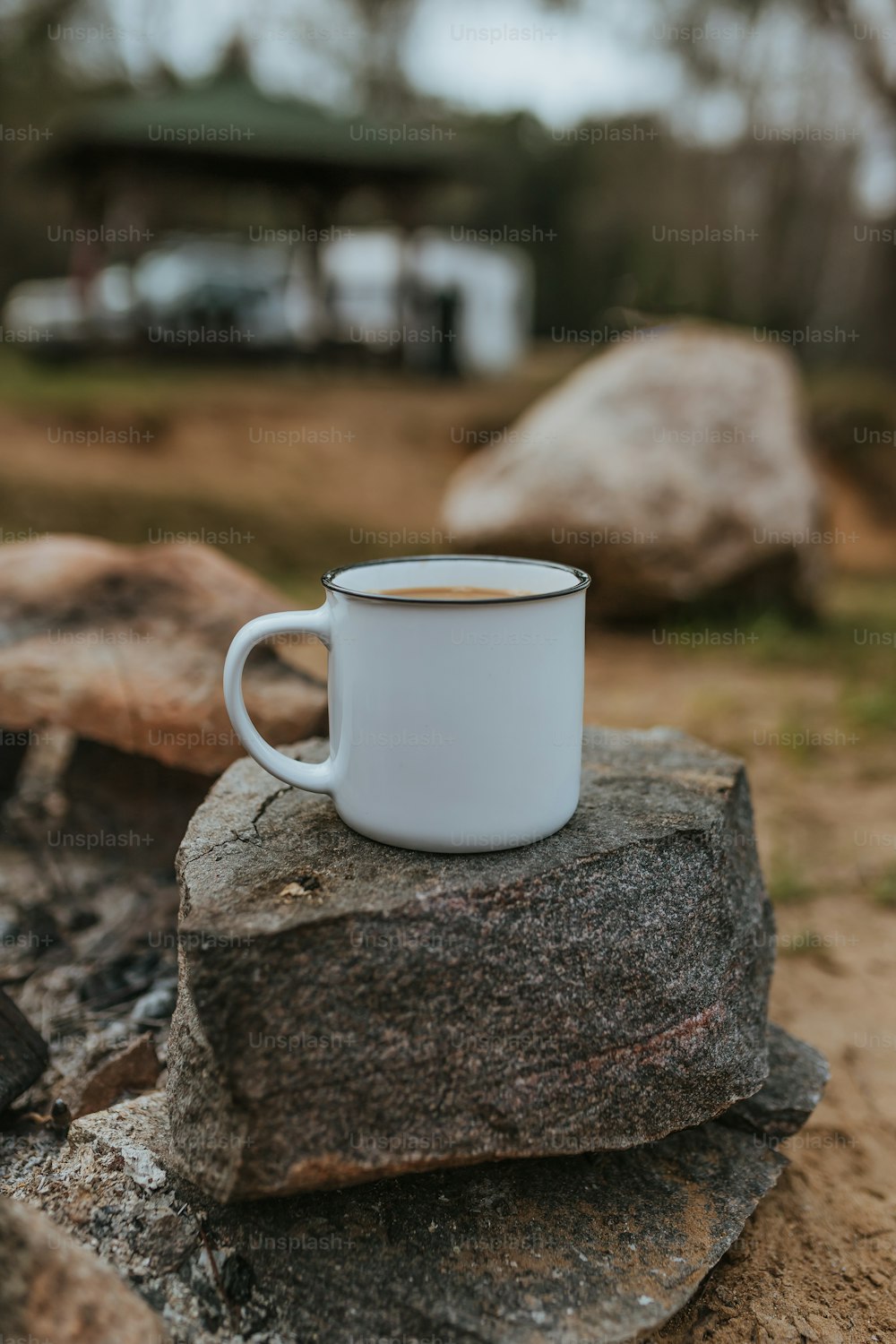 Una taza de café sentado encima de una roca