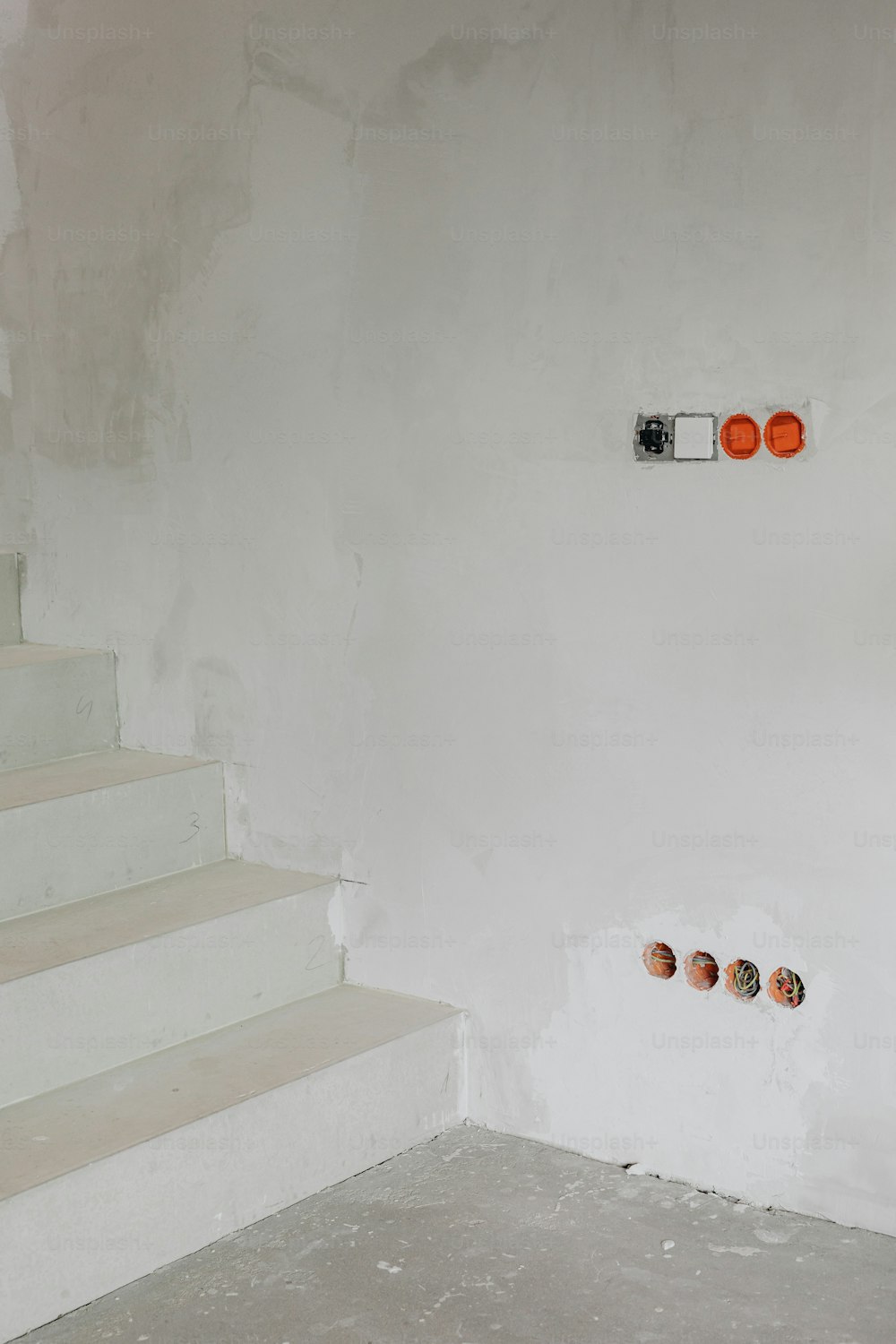 a set of stairs leading up to a white wall