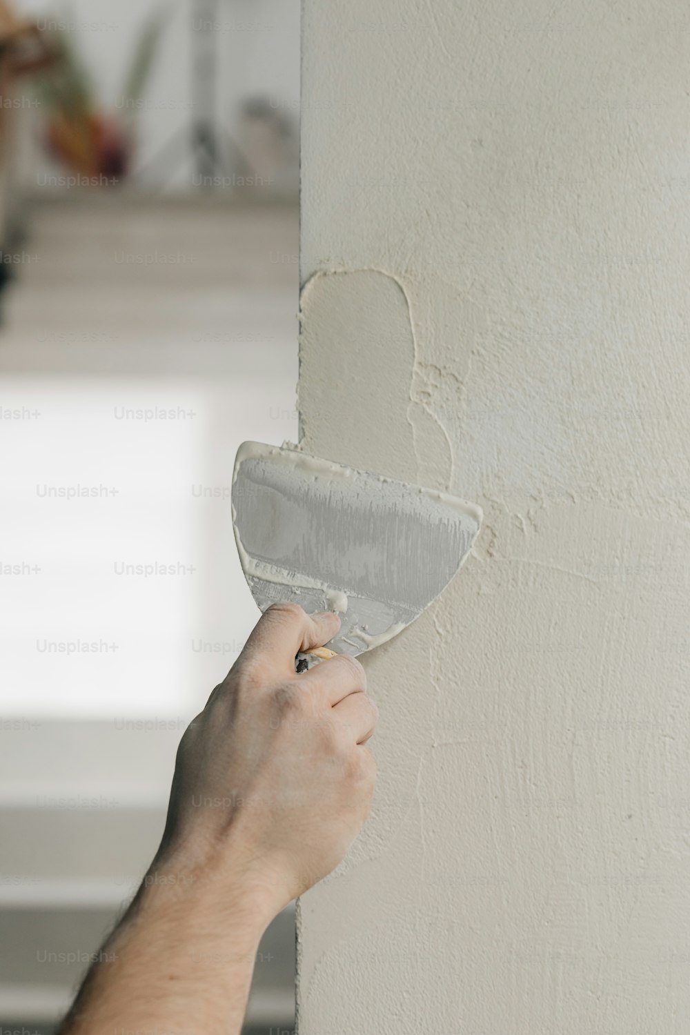 Una persona pintando una pared con un rodillo de pintura