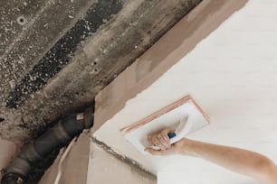 a person using a paint roller to paint a wall